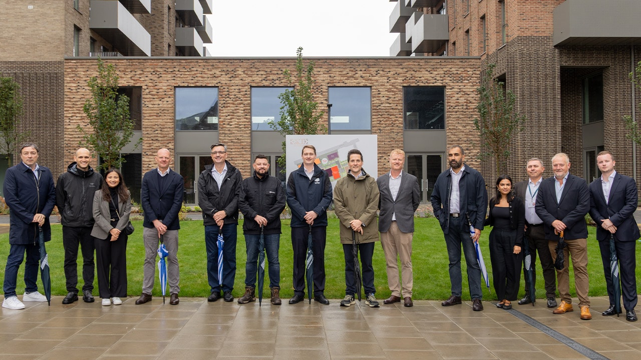 Representatives from partner organisations stand in the landscaped courtyard of the completed One Goodmayes development in Redbridge.