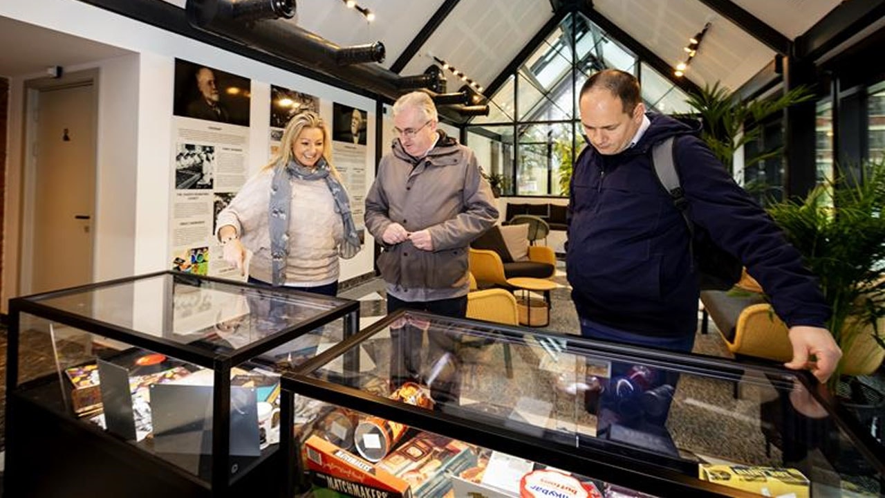 Three people looking inside a glass display 