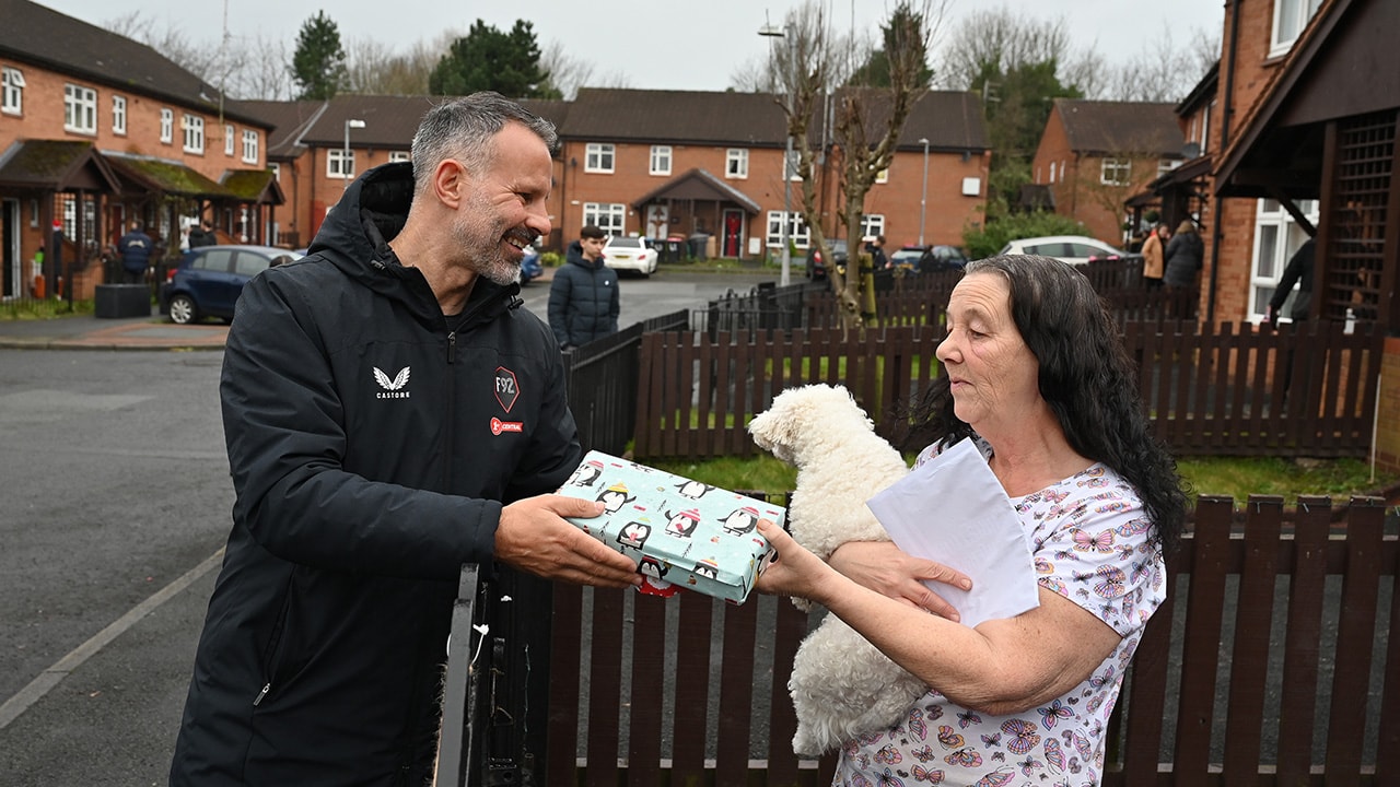 Ryan Giggs hands out a Christmas gift to a Clarion resident in Salford